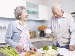 笑顔で料理をする老夫婦